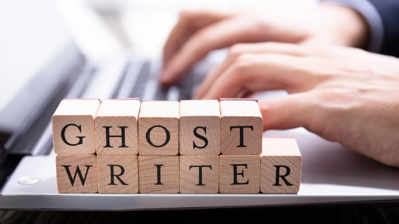 Mestiere del ghostwriter rappresentato da scritta su cubi davanti a tastiera